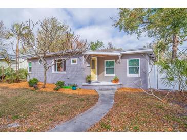 Charming home featuring a neatly landscaped front yard with a walkway leading to a yellow front door at 4545 6Th N Ave, St Petersburg, FL 33713