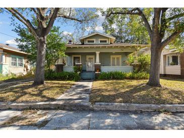Charming craftsman style home featuring a covered porch, lush landscaping, and a welcoming entrance at 306 S Albany Ave, Tampa, FL 33606