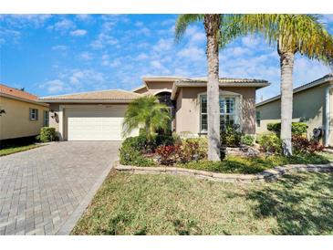 Charming single-story home with well-manicured landscaping and a brick driveway at 16135 Cape Coral Dr, Wimauma, FL 33598