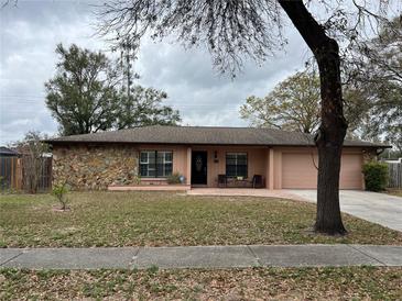 Charming single-story home with stone accents, a well-manicured lawn, and front porch at 6620 Jennifer Dr, Temple Terrace, FL 33617