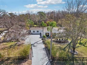 Inviting property showcases a spacious driveway, lush landscaping, and a charming white home at 8376 Sycamore Dr, New Port Richey, FL 34654