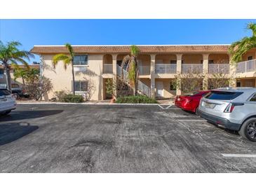 Two-story condo building with a light stucco facade and well-maintained landscaping at 9060 Blind Pass Rd # 28, St Pete Beach, FL 33706