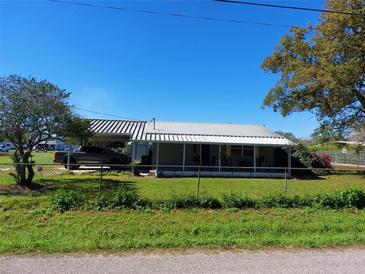 Charming single-story home with a metal roof, fenced yard, and mature trees at 1115 27Th Se St, Ruskin, FL 33570