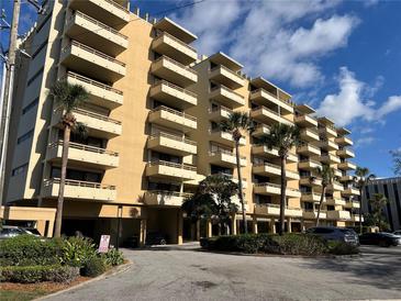 Low angle shows the exterior of the condo building with palm trees and parking at 5701 Mariner St # 606, Tampa, FL 33609