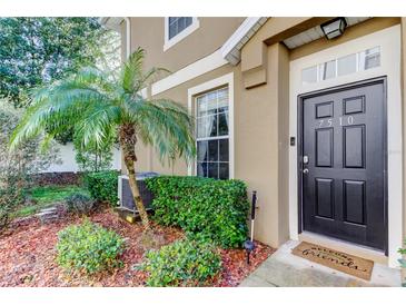 Inviting front entrance showcasing a dark door, well-manicured landscaping, and a welcoming doormat at 7510 Red Mill Cir, New Port Richey, FL 34653