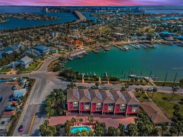 Breathtaking aerial view of waterfront townhomes with a community pool and Gulf access at 3390 W Maritana Dr # 4, St Pete Beach, FL 33706