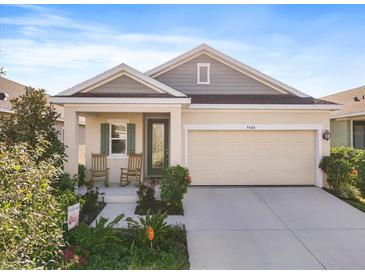 Charming single-Gathering home featuring a two-car garage and a welcoming front porch with rocking chairs at 5566 Silver Sun Dr, Apollo Beach, FL 33572