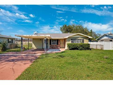 Charming single-story home with a well-maintained lawn, carport, and inviting curb appeal under a blue sky at 2713 W Osborne Ave, Tampa, FL 33614