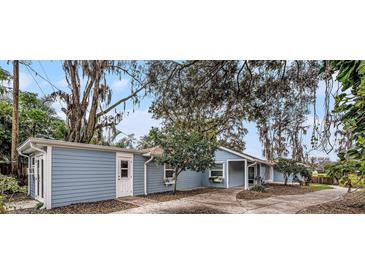 Charming single-story home featuring light blue siding, flower boxes, and a spacious front yard area at 8922 Donna Lu Dr, Odessa, FL 33556
