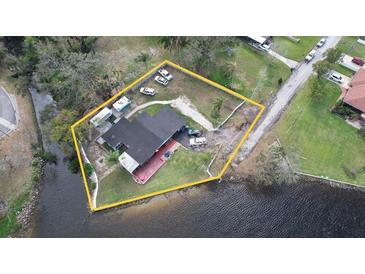 An aerial view of waterfront property with a home, mature trees and driveway parking for multiple vehicles at 2102 W Ivy St, Tampa, FL 33607