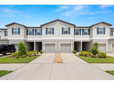 Charming townhome showcasing a two-story facade, driveway and a well-manicured front lawn at 9716 Mulberry Marsh Ln, Sun City Center, FL 33573