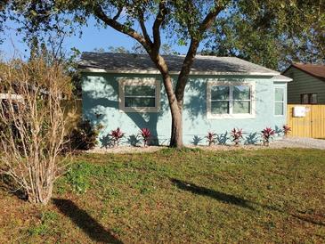 Charming, light blue single-story home with tidy landscaping, lush lawn, and mature tree at 2432 Auburn S St, St Petersburg, FL 33712