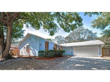 Charming light blue single-story home featuring a two-car garage and well-maintained landscaping at 2580 Redwood Way, Clearwater, FL 33761