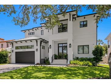 Stunning two-story home featuring a modern design, lush landscaping, and a spacious two-car garage at 5004 S The Riviera, Tampa, FL 33609