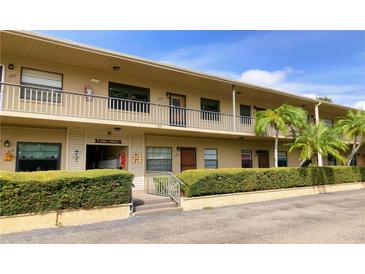 Two-story condo building showcasing well-maintained landscaping and exterior walkways at 5925 Terrace Park N Dr # 111, St Petersburg, FL 33709