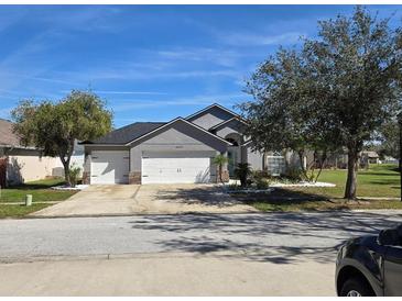 Charming single-story home with a three-car garage, lush landscaping, and a well-maintained lawn at 6601 Thackston Dr, Riverview, FL 33578