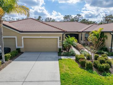 Charming single-story home featuring a tile roof, a two-car garage, and well-manicured landscaping at 438 Seneca Falls Dr, Apollo Beach, FL 33572