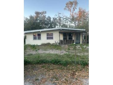 Home exterior needing TLC, featuring a covered front porch and barred windows for enhanced security at 926 E 120Th Ave, Tampa, FL 33612