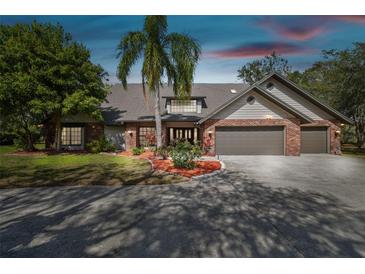 Charming brick home featuring a well-maintained yard, mature landscaping, and a spacious driveway at 1902 Sweet Bay Ct, Plant City, FL 33566