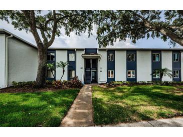Well-maintained condo building with mature trees and green lawn, located at 3435 Cove Isle Dr #256, Tampa, FL at 256 Cypress Ln # 120, Oldsmar, FL 34677