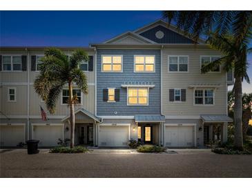 Charming townhome exterior featuring well-manicured landscaping, private garages, and a welcoming facade at twilight at 3226 Nautical S Pl, St Petersburg, FL 33712