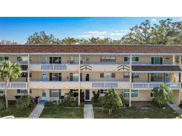 Three-story condo building with balconies, mature trees, and well-maintained landscaping at 2041 Australia W Way # 35, Clearwater, FL 33763