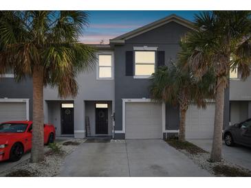 Inviting two-story townhome featuring an attached garage, palm trees, and a welcoming front entrance at 3313 Pleasant Willow Ct, Brandon, FL 33511