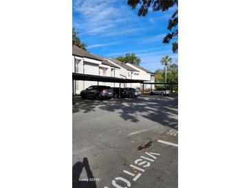 Exterior view of covered parking spaces with multiple vehicles parked on a sunny day at 5162 Puritan Cir # 5162, Tampa, FL 33617