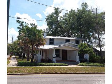 Inviting two-story home featuring a charming front porch, lush landscaping, and a classic architectural style at 1001 W Baker St, Plant City, FL 33563