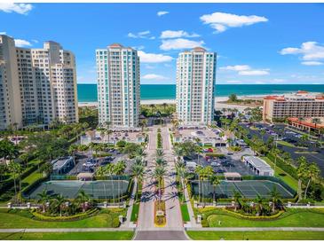 Beautiful aerial view of beachfront condos, tennis courts, and well-manicured landscaping on a sunny day at 1170 Gulf Blvd # 2001, Clearwater, FL 33767