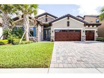 Charming single-Gathering home with a well-manicured lawn, stone facade, and a three-car garage at 21807 Amelia Rose Way, Land O Lakes, FL 34637