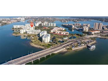 Gorgeous aerial view of a waterfront property with white buildings, lush landscaping, and bridge access at 7902 Sailboat Key S Blvd # 206, South Pasadena, FL 33707