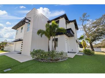 Modern home with black trim, white walls, and a well-manicured front yard at 902 W Sligh Ave, Tampa, FL 33604