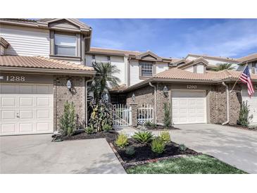 Charming townhome with attached garages, well-manicured landscaping, and a welcoming front entrance at 1290 Clays Trl, Oldsmar, FL 34677