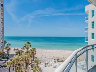 Expansive beach view from the condo balcony, overlooking white sands, turquoise water, and palm trees at 1590 Gulf Blvd # 501, Clearwater Beach, FL 33767
