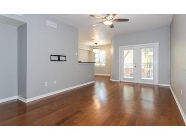 Open living room boasts beautiful hardwood floors and glass doors leading to the outdoor patio at 2010 E Palm Ave # 14206, Tampa, FL 33605