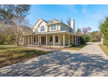 Inviting two-story home with a long porch and classic architectural details on a bright, sunny day at 6615 Ridge Top Dr, Trinity, FL 34655