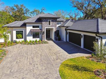 Beautiful home featuring a paved driveway, manicured lawn, and attached two-car garage at 906 S Sterling Ave, Tampa, FL 33629