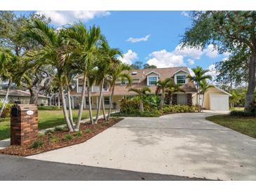 Charming two-story home featuring mature palm trees and a spacious driveway at 10635 Huston Ln, Largo, FL 33774