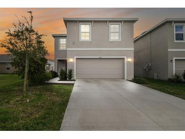 Charming two-story home featuring a neutral color scheme, manicured lawn, and a spacious two-car garage at 16126 Sunday Stroll Way, Odessa, FL 33556