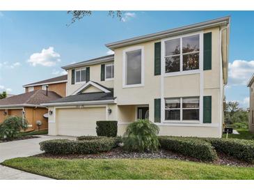 Two-story home with a well-maintained lawn, lush shrubbery and attached two car garage and large windows at 20115 Nob Oak Ave, Tampa, FL 33647
