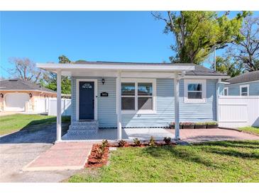 Charming single-story home featuring a cozy covered porch, brick walkway, and well-maintained lawn at 7015 N Dakota Ave, Tampa, FL 33604