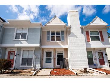 Charming townhome featuring a brick chimney, neutral palette, and well-maintained front yard at 11338 Stratton Park Dr # 11338, Temple Terrace, FL 33617