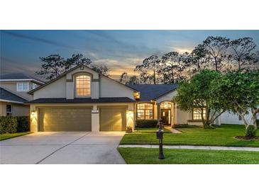 Charming single-Gathering home featuring a well-manicured lawn and a two-car garage against a picturesque evening sky at 12906 Tar Flower Dr, Tampa, FL 33626