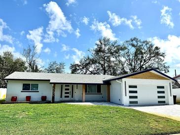 Charming single-story home boasts fresh white paint, modern garage door and well-manicured lawn at 3735 69Th N Way, St Petersburg, FL 33710