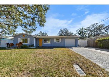 Charming single-story home with a well-maintained lawn, driveway, and a cheerful yellow front door at 1101 Jackmar Rd, Dunedin, FL 34698