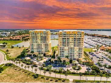 Stunning aerial view of waterfront condos with beautiful sunset and manicured lawns at 130 Riviera Dunes Way # 606, Palmetto, FL 34221