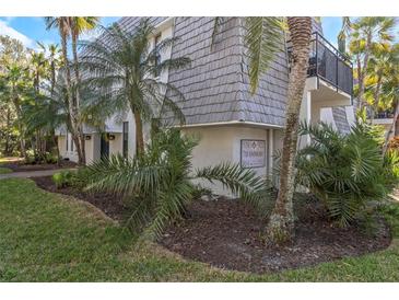 Condo exterior featuring lush landscaping with palms and a building directory at 718 Lyndhurst St # 904, Dunedin, FL 34698