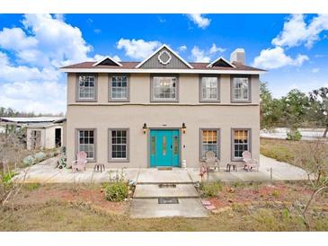 Two-story home featuring a blue front door and symmetrical window placement at 11050 Revell Rd, Duette, FL 34219