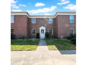 Charming red brick building featuring a classic white door and ample natural light from many windows at 1142 84Th N Ter # C, St Petersburg, FL 33702
